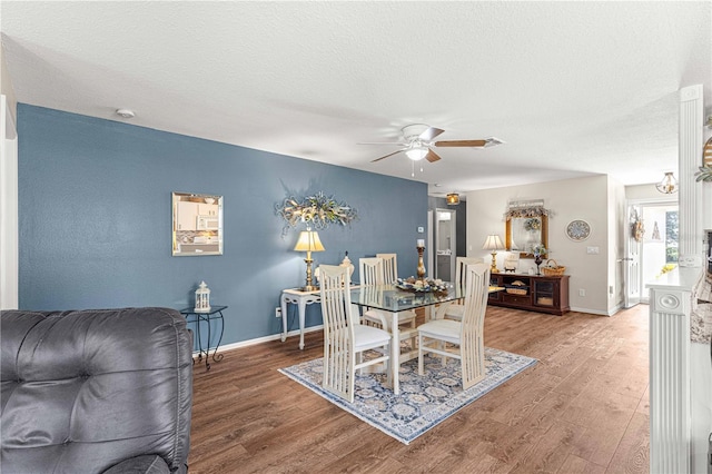 dining room featuring wood-type flooring, a textured ceiling, and ceiling fan