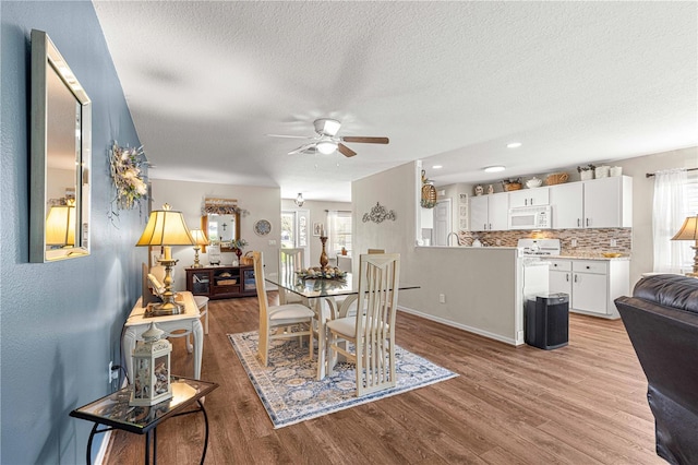 dining area featuring plenty of natural light, ceiling fan, a textured ceiling, and light hardwood / wood-style flooring