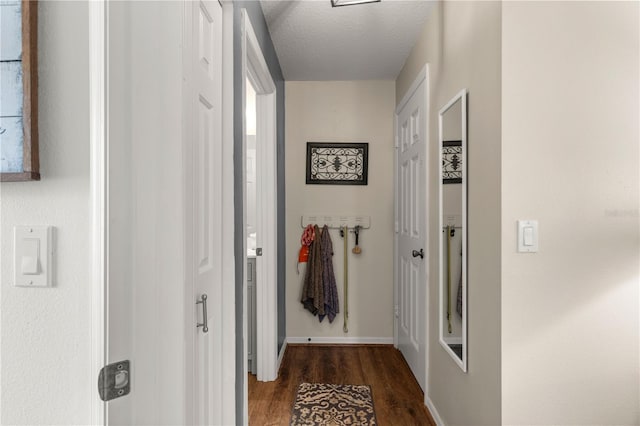 hall featuring a textured ceiling and dark hardwood / wood-style floors