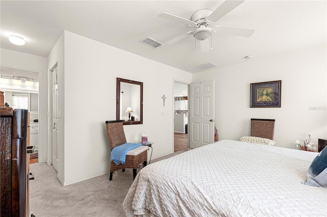 bedroom with ceiling fan, light colored carpet, and a textured ceiling