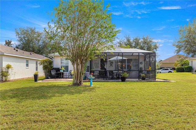 back of house featuring glass enclosure, a patio area, and a lawn