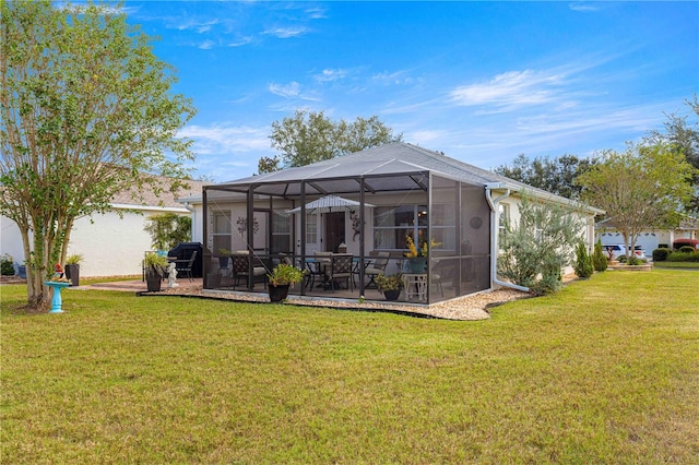 rear view of house featuring a lanai, a patio area, and a yard