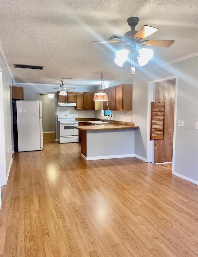 kitchen featuring white appliances, a textured ceiling, kitchen peninsula, crown molding, and light hardwood / wood-style flooring