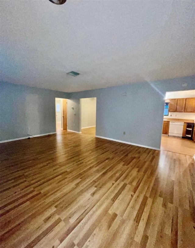 unfurnished living room with light hardwood / wood-style floors and a textured ceiling