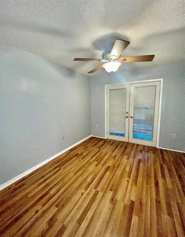 spare room featuring french doors, a textured ceiling, wood-type flooring, and ceiling fan