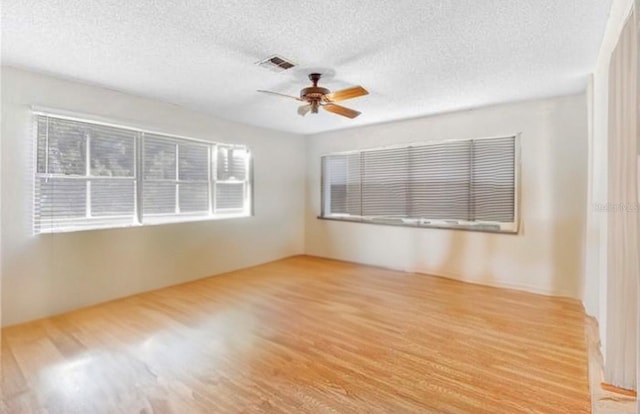 unfurnished room featuring ceiling fan, a textured ceiling, and light hardwood / wood-style flooring