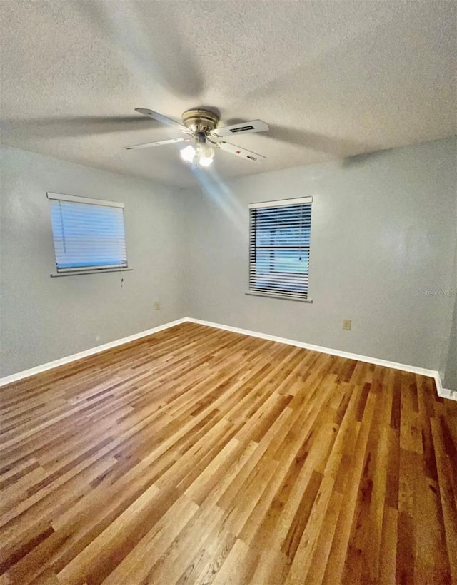 empty room featuring ceiling fan, a textured ceiling, and hardwood / wood-style floors