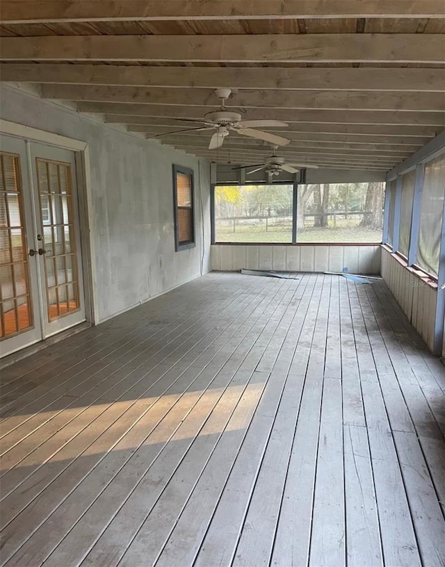 unfurnished sunroom featuring french doors, a healthy amount of sunlight, and ceiling fan