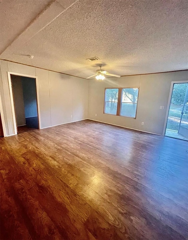 empty room with hardwood / wood-style floors, a textured ceiling, and ceiling fan