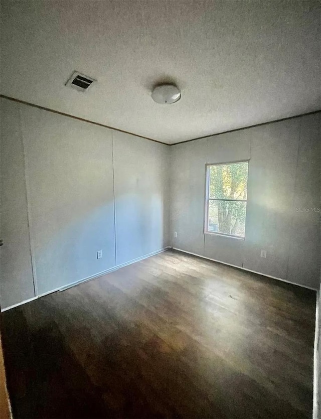 unfurnished room featuring a textured ceiling