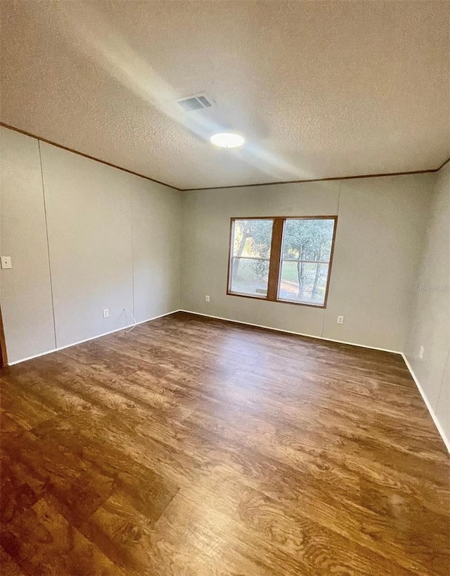 spare room with a textured ceiling and wood-type flooring