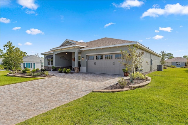 view of front of property featuring a front lawn, central AC unit, and a garage