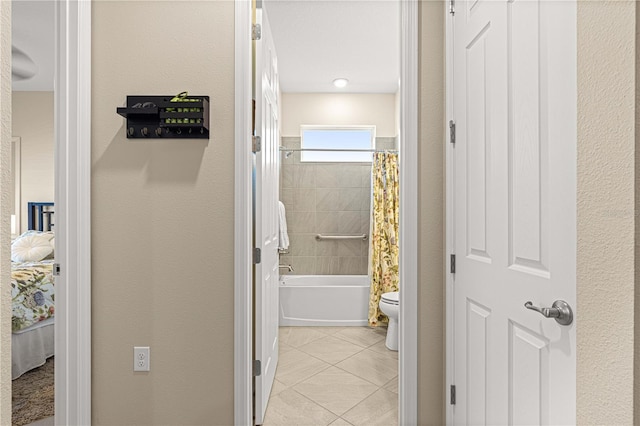 bathroom with tile patterned floors, shower / bath combination with curtain, and toilet