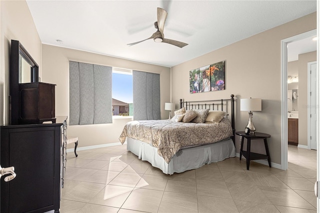 tiled bedroom featuring ceiling fan and ensuite bath