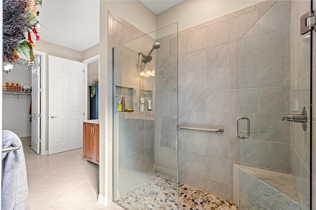 bathroom featuring vanity, a shower with shower door, and tile patterned floors