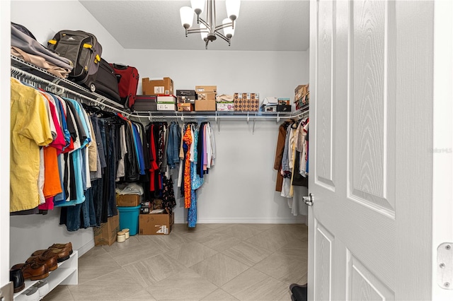 spacious closet featuring a chandelier