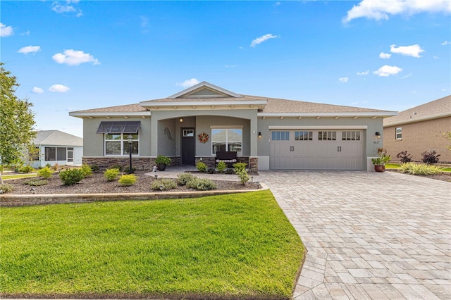 9617 SW 102nd Ter, Ocala, FL 34481 - view of front of property featuring stucco siding, an attached garage, stone siding, decorative driveway, and a front yard