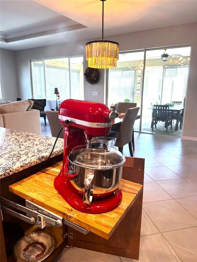 tiled dining space with a tray ceiling