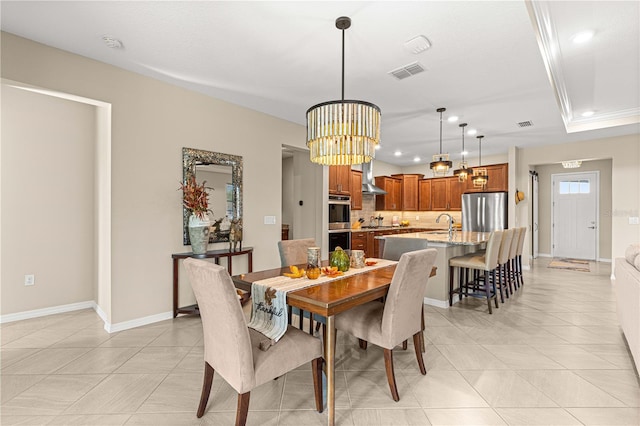 dining space with sink, crown molding, a notable chandelier, and light tile patterned floors