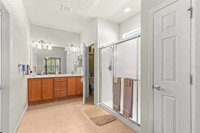 bathroom with vanity, a shower with shower door, a textured ceiling, and toilet