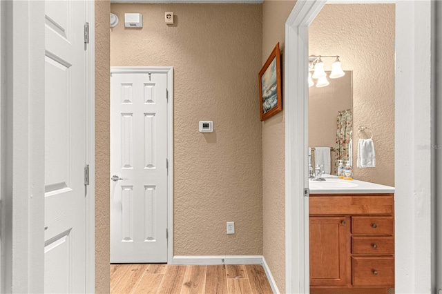 hallway featuring light hardwood / wood-style floors and sink