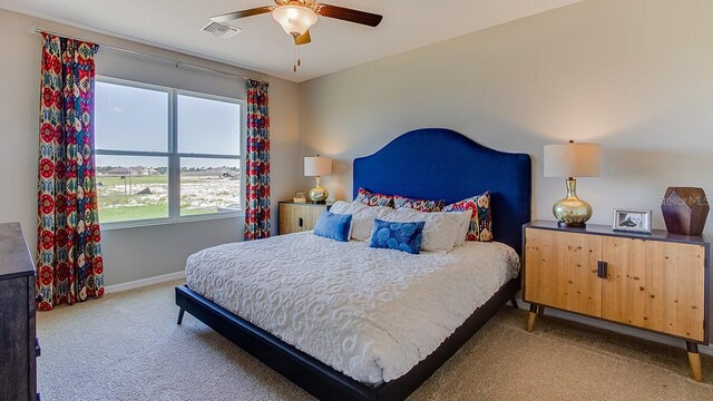 bedroom featuring ceiling fan, multiple windows, and light colored carpet