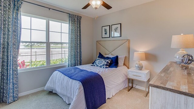 carpeted bedroom with multiple windows and ceiling fan