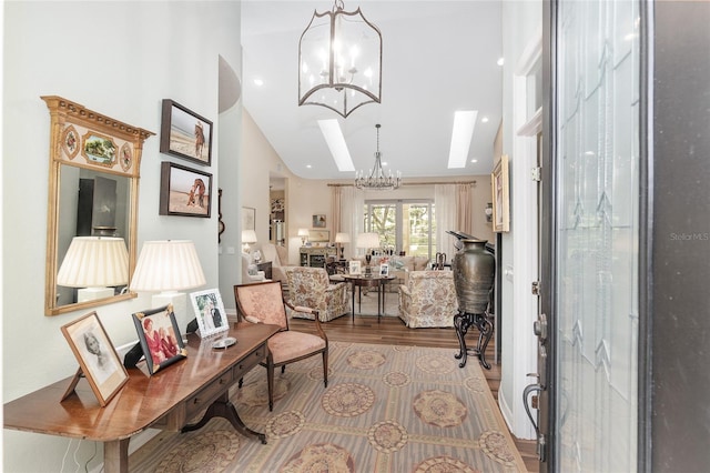 foyer featuring an inviting chandelier, light hardwood / wood-style flooring, and a skylight