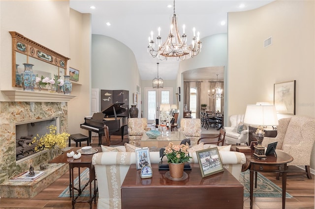 living room with a high end fireplace, high vaulted ceiling, and wood-type flooring