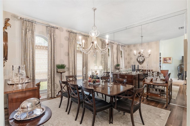 dining area with wood-type flooring and an inviting chandelier