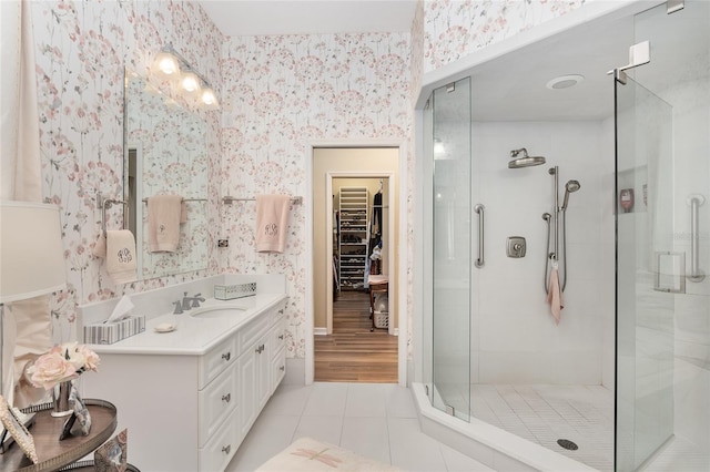 bathroom featuring a shower with door, vanity, and tile patterned flooring