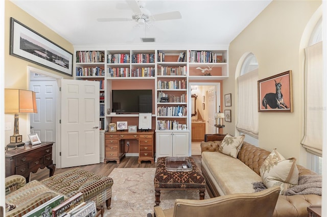 living area featuring hardwood / wood-style floors and ceiling fan