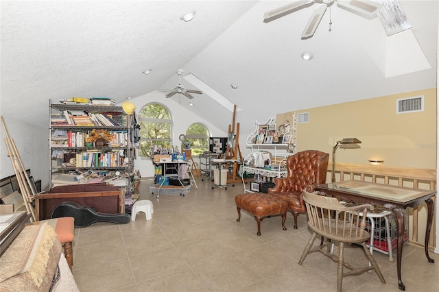 sitting room with lofted ceiling with skylight and ceiling fan