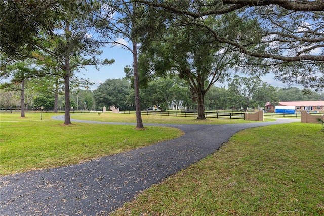 view of property's community with a rural view and a lawn