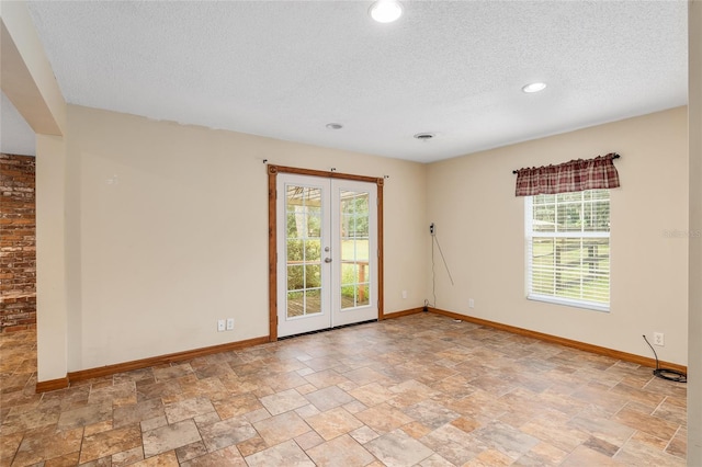 spare room featuring french doors and a textured ceiling