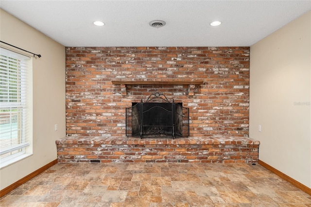 interior details featuring a textured ceiling and a fireplace