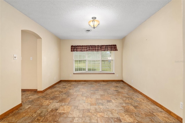 unfurnished room with a textured ceiling