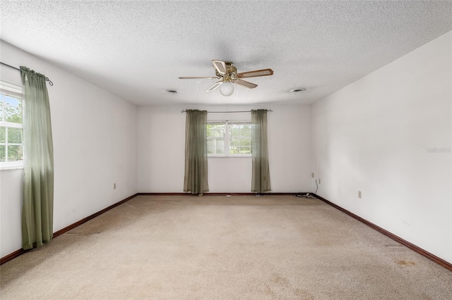 carpeted empty room with a textured ceiling and ceiling fan