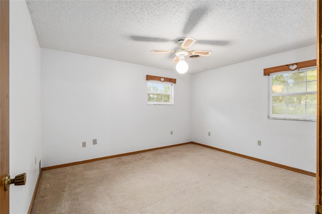 spare room featuring light carpet, a textured ceiling, and ceiling fan