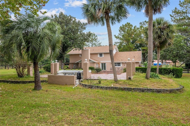 back of house with a yard and a patio