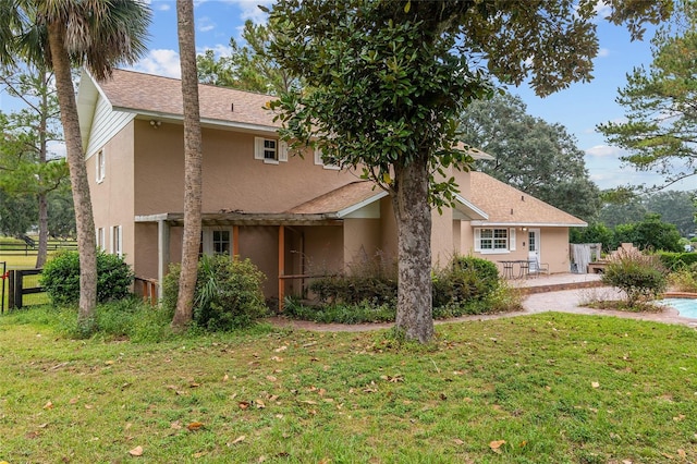 back of property with a patio and a yard