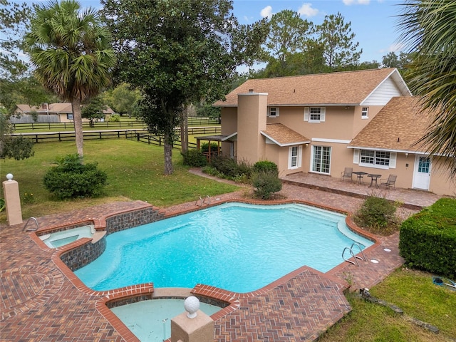 view of swimming pool with a yard, a patio area, and an in ground hot tub