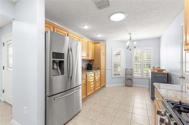 kitchen featuring pendant lighting, light brown cabinets, an inviting chandelier, light stone counters, and stainless steel appliances