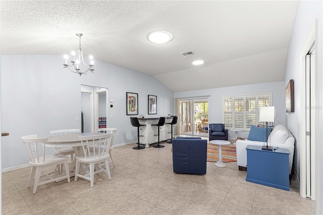 living room with an inviting chandelier, visible vents, a textured ceiling, and vaulted ceiling