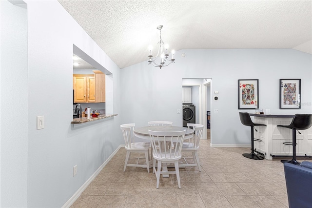 dining space with a dry bar, a textured ceiling, vaulted ceiling, a chandelier, and baseboards