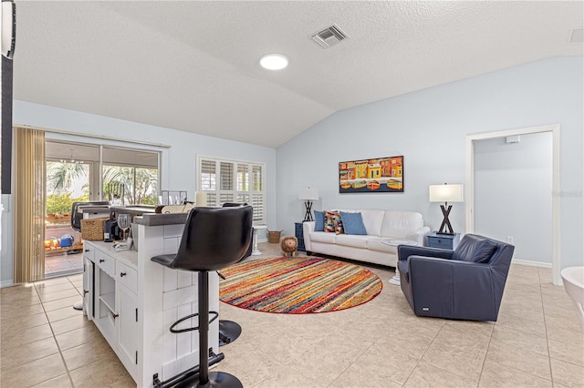 living room featuring light tile patterned floors, a textured ceiling, and vaulted ceiling