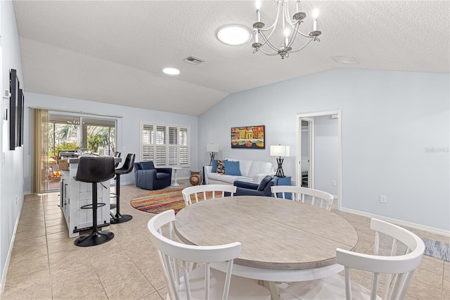 dining room with a textured ceiling, an inviting chandelier, lofted ceiling, and light tile patterned flooring