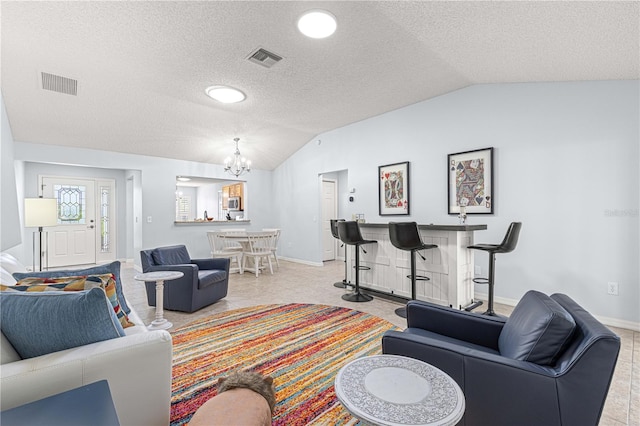 tiled living room with a chandelier, a textured ceiling, and vaulted ceiling