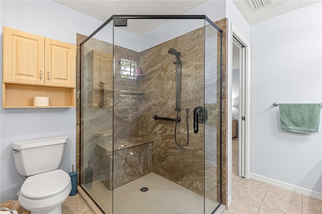 bathroom featuring a textured ceiling, tile patterned flooring, an enclosed shower, and toilet