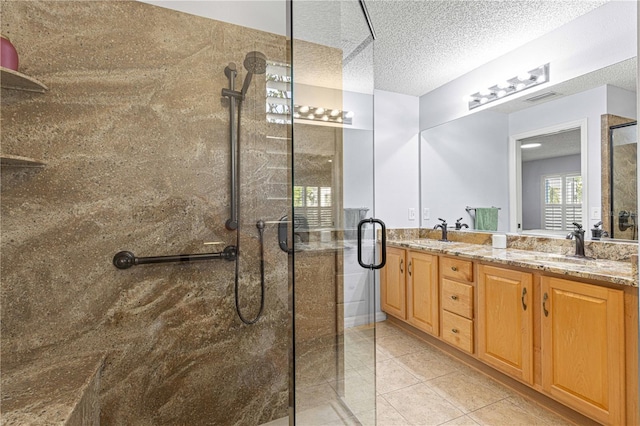 full bathroom with double vanity, a sink, a textured ceiling, visible vents, and a shower stall